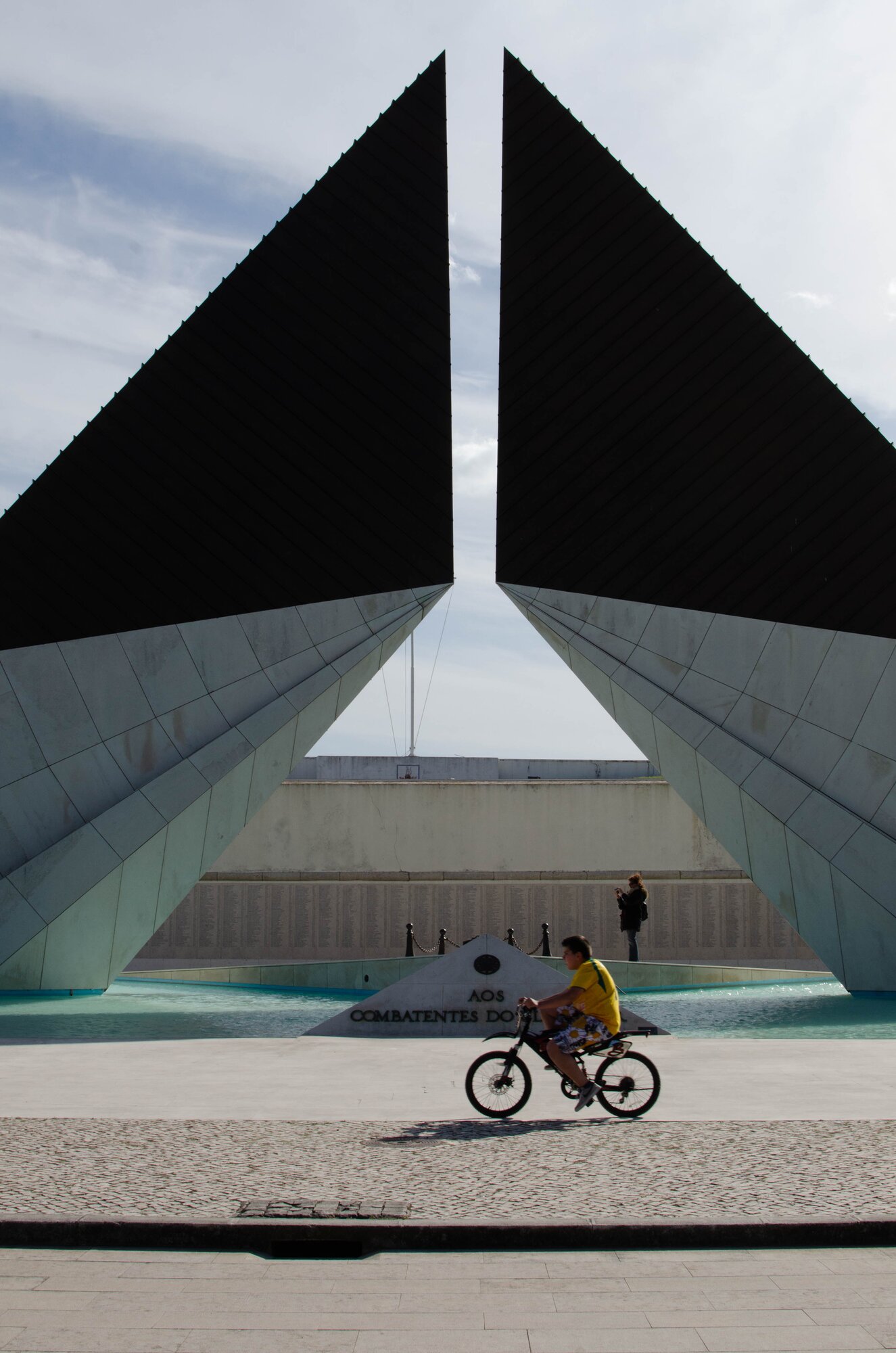 Monumento aos Combatentes do Ultramar — Belém. Linhas diagonais, ciclista como escala.